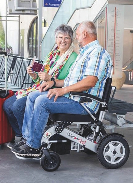 Ein Rollstuhlfahrer und neben ihm sitzt eine Frau